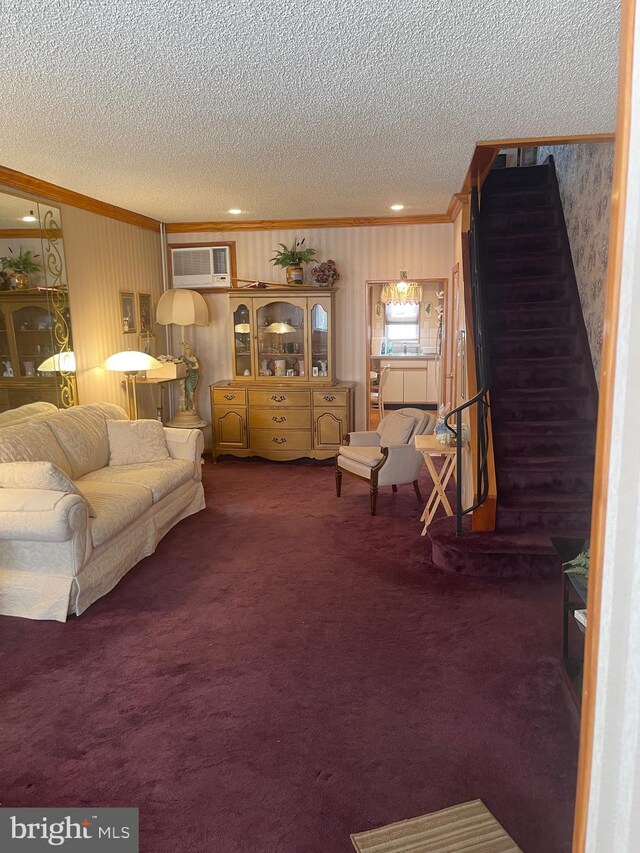 living area with ornamental molding, a textured ceiling, stairs, carpet, and a wall unit AC
