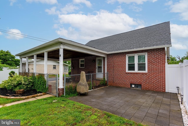 527 Eshelman St, Highspire, PA 17034 - rear view of house featuring brick siding, a shingled roof, a gate, and a patio