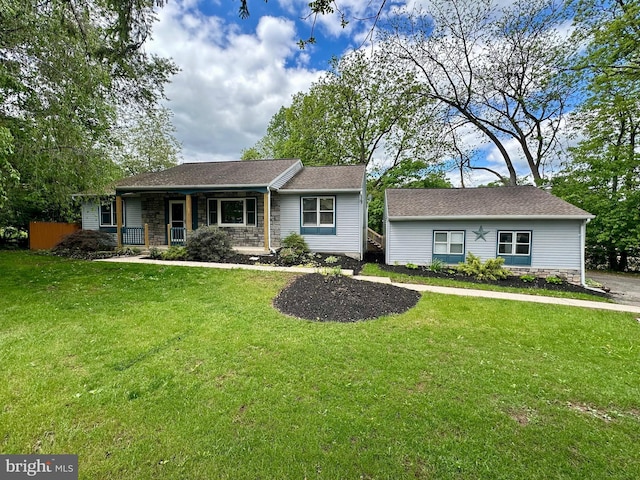 view of front of house with stone siding, covered porch, and a front yard