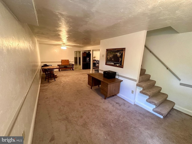 living area featuring carpet flooring, stairs, and ceiling fan
