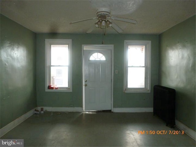 entryway featuring a ceiling fan and baseboards