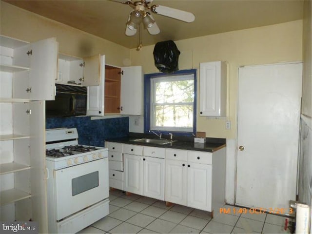 kitchen with open shelves, white gas range, black microwave, and a sink