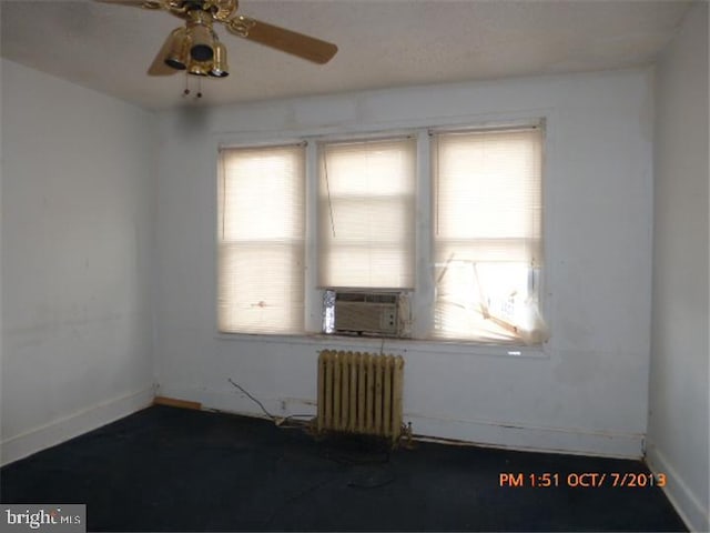 unfurnished room with radiator, plenty of natural light, baseboards, and a ceiling fan