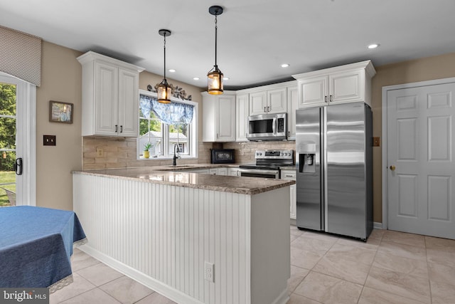 kitchen featuring stainless steel appliances, a peninsula, a sink, decorative backsplash, and recessed lighting