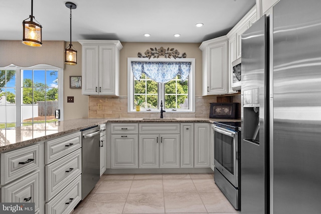 kitchen featuring stainless steel appliances, a sink, plenty of natural light, white cabinets, and recessed lighting