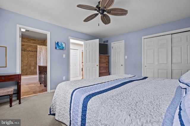 bedroom featuring light colored carpet, a ceiling fan, and connected bathroom