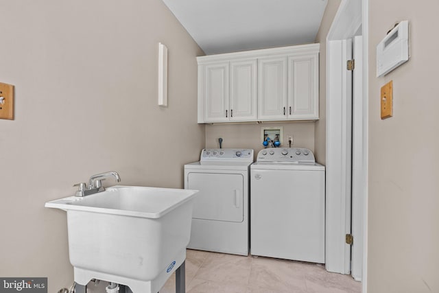 laundry area with washing machine and dryer, cabinet space, and light tile patterned floors