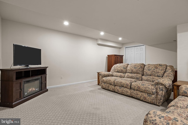 living area with carpet floors, baseboards, recessed lighting, and a glass covered fireplace