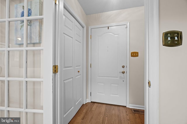 doorway to outside with wood finished floors and baseboards