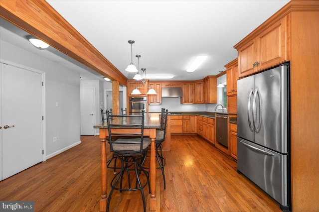 4211 Springview, Jefferson, MD 21755 - kitchen featuring appliances with stainless steel finishes, ventilation hood, dark countertops, dark wood-style flooring, and brown cabinetry