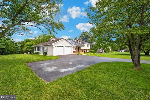 4211 Springview, Jefferson, MD 21755 - view of front of property featuring asphalt driveway, a garage, a front yard, and a chimney