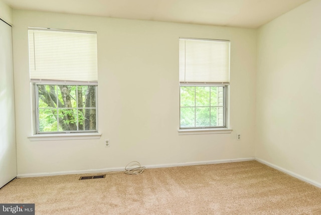 carpeted empty room featuring baseboards