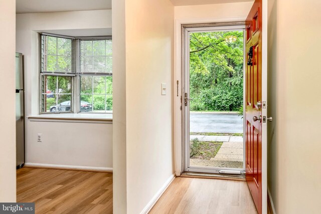 doorway to outside featuring wood finished floors and baseboards