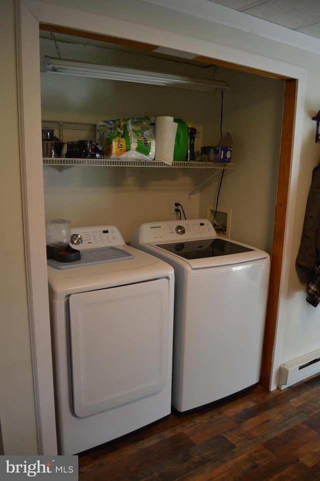 laundry room featuring a baseboard heating unit, washer and dryer, and dark wood-type flooring