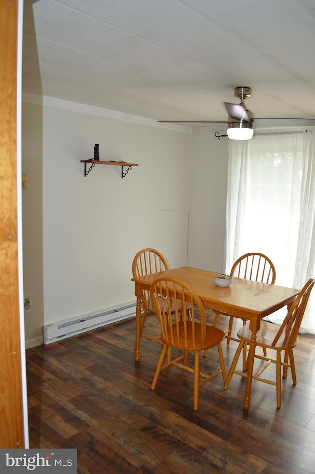dining room featuring a baseboard heating unit, crown molding, and wood finished floors