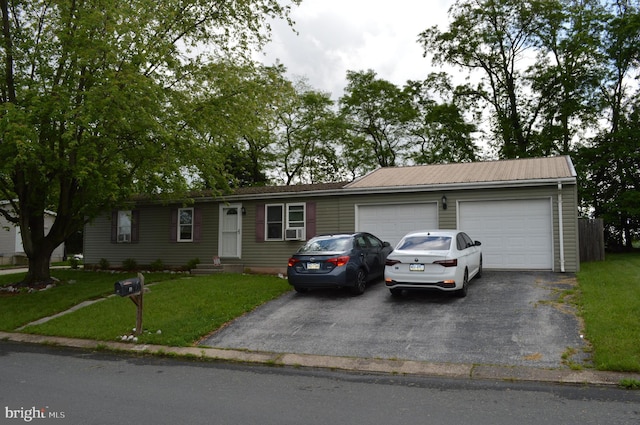 ranch-style home with driveway, an attached garage, and a front lawn