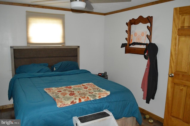 bedroom with baseboards, crown molding, ceiling fan, and wood finished floors