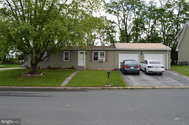 single story home with driveway, an attached garage, a front yard, and cooling unit