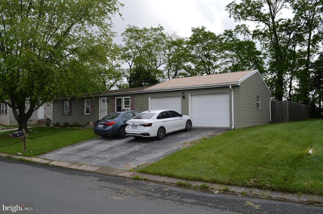 ranch-style home with asphalt driveway, an attached garage, and metal roof