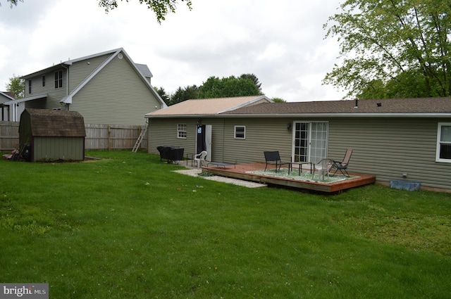 rear view of house featuring a deck, a shed, and an outbuilding
