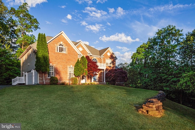 view of front of property with an attached garage, brick siding, and a front lawn