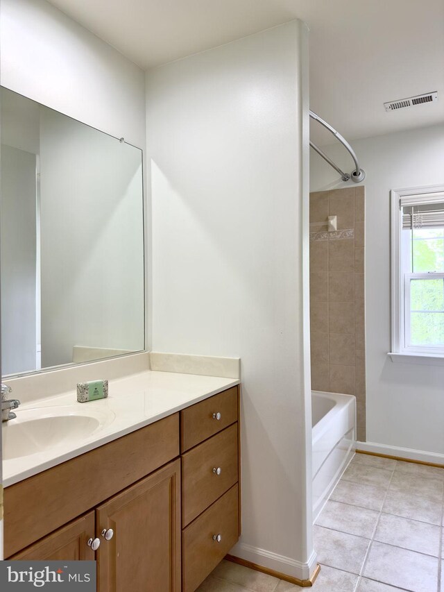 full bath featuring baseboards, vanity, tile patterned flooring, and bathing tub / shower combination