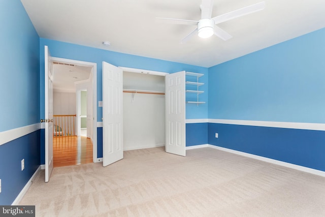 unfurnished bedroom featuring carpet, a closet, baseboards, and ceiling fan