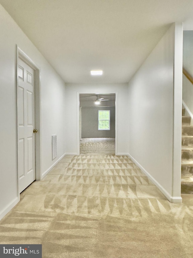 carpeted spare room with stairs and baseboards
