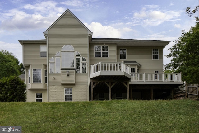 rear view of property featuring a lawn and a wooden deck