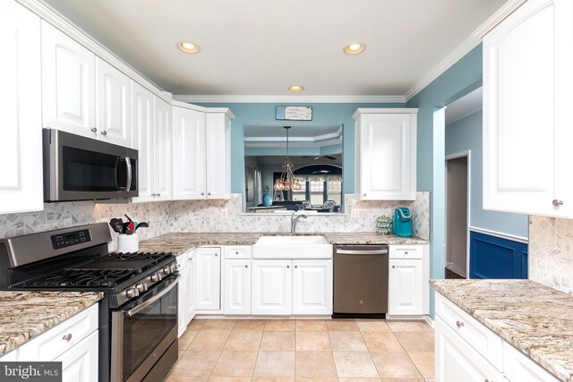 31766 Chablis Ln Unit 76, Lewes, DE 19958 - kitchen with appliances with stainless steel finishes, a sink, decorative backsplash, white cabinetry, and a chandelier