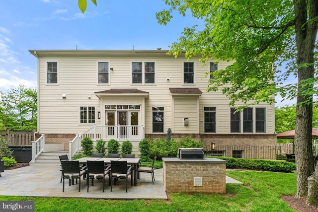rear view of property featuring a patio area, brick siding, and a lawn