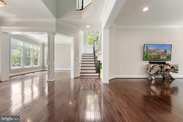 unfurnished living room with ornate columns, dark wood-type flooring, stairway, healthy amount of natural light, and ornamental molding