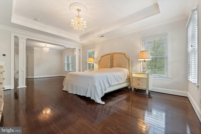 bedroom featuring a chandelier, hardwood / wood-style floors, a raised ceiling, and crown molding