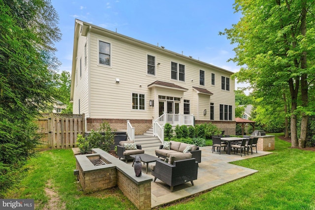 back of house with a patio, brick siding, and an outdoor living space with a fire pit