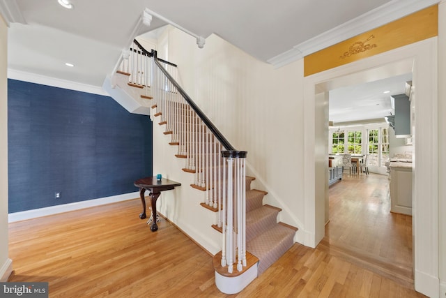 staircase featuring wood finished floors, baseboards, crown molding, and recessed lighting