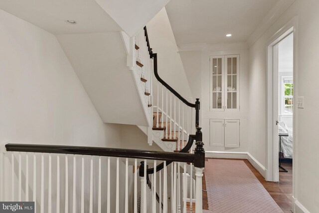 staircase featuring wood finished floors, baseboards, and recessed lighting