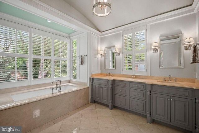 bathroom featuring vaulted ceiling, a bath, healthy amount of natural light, double vanity, and tile patterned floors
