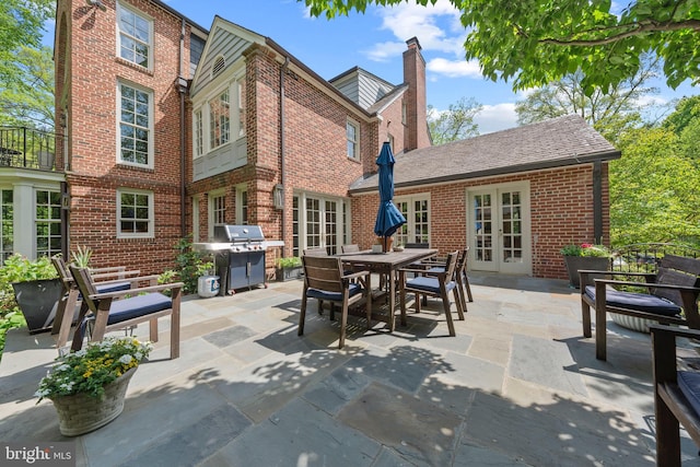 view of patio with french doors, area for grilling, and outdoor dining space