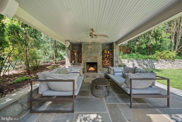 view of patio with ceiling fan and an outdoor living space with a fireplace