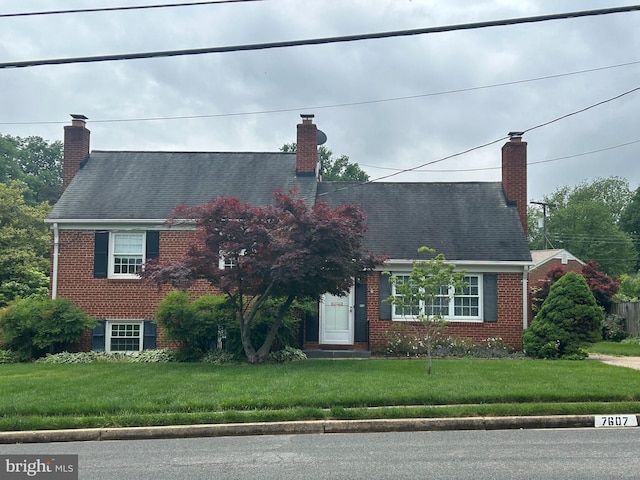 7607 Newcastle Dr, Annandale, VA 22003 - cape cod home featuring a chimney, brick siding, and a front yard