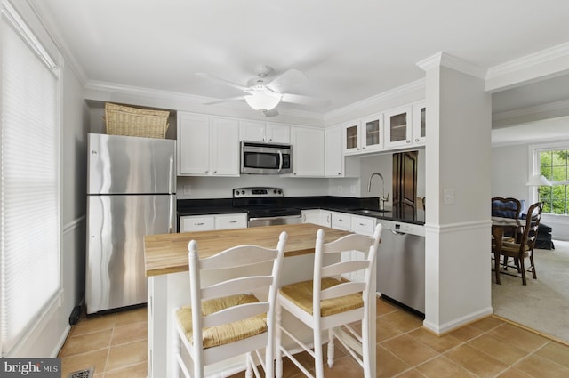 1920 Belmont Ridge Ct, Reston, VA 20191 - kitchen featuring stainless steel appliances, butcher block counters, a sink, crown molding, and glass insert cabinets