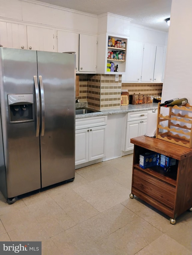 kitchen featuring stainless steel refrigerator with ice dispenser, white cabinets, decorative backsplash, open shelves, and crown molding