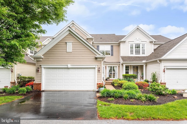 view of front of home featuring driveway and roof with shingles