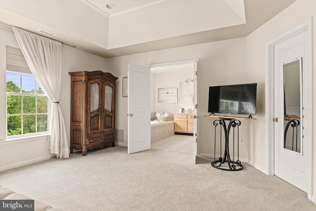 bedroom with light colored carpet, baseboards, and ensuite bath