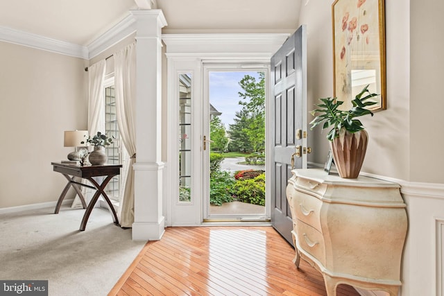 entrance foyer with crown molding, light wood-type flooring, and decorative columns