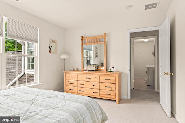 bedroom with light colored carpet and baseboards