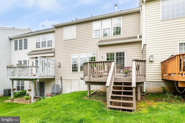 rear view of house featuring central AC unit, a wooden deck, and a lawn
