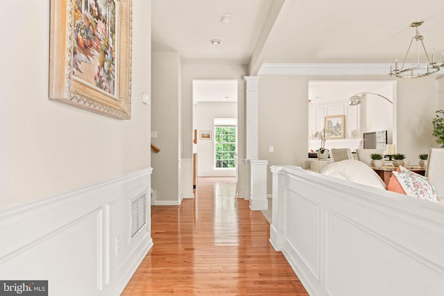 corridor featuring light wood-style flooring and a chandelier