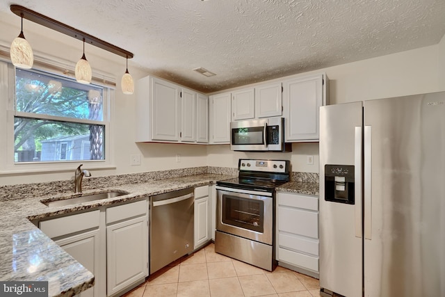 8838 Cross Country Pl, Gaithersburg, MD 20879 - kitchen featuring appliances with stainless steel finishes, a sink, light stone counters, white cabinets, and a textured ceiling