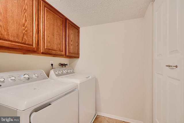 8838 Cross Country Pl, Gaithersburg, MD 20879 - clothes washing area featuring separate washer and dryer, cabinet space, light tile patterned floors, a textured ceiling, and baseboards